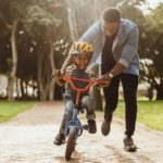 Father helping son ride bike