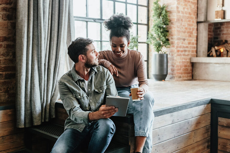 Couple in modern loft using tablet.