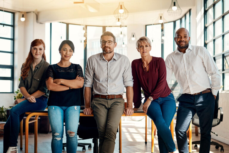 Group of five confident people in a conference room.