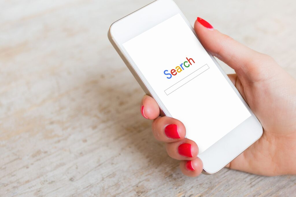 search displayed on mobile phone in woman's hand
