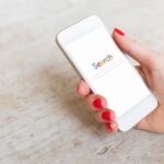 search displayed on mobile phone in woman's hand