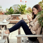 women using her phone to shop for a new home